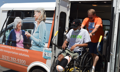 A person using a wheelchair exits a van.