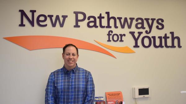 Scott Smith poses for a photo at the New Pathways for Youth office front desk